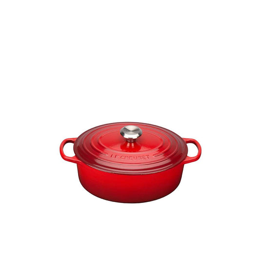 Der Le Creuset Signature Bräter oval 29 cm überzeugt in Rot mit emaillierter Innenseite, dicht schließendem Deckel, silbernem Knauf und zwei Seitengriffen - stilvoll vor weißem Hintergrund präsentiert.